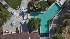 an overhead view of a swimming pool with tables and chairs at Palazzo Navarone in Lindos +46 photos