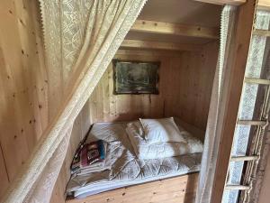 a small bed in a wooden cabin with a window at Cozy Off-Grid Cabin - No Power, No Running Water in Skretteberg +24 photos
