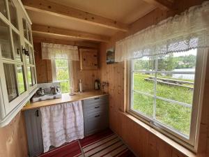 a kitchen with a window in a log cabin at Cozy Off-Grid Cabin - No Power, No Running Water in Skretteberg