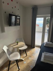 a living room with a table and chairs and a tv at Villa Šimović in Baška Voda
