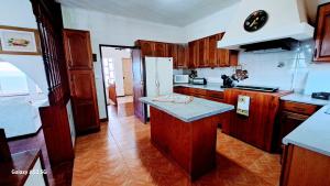 a kitchen with wooden cabinets and a counter top at Casa da Maíssa in Ponta Delgada +29 photos