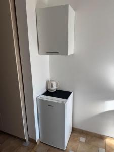 a small white refrigerator with a microwave on top of it at Villa Šimović in Baška Voda