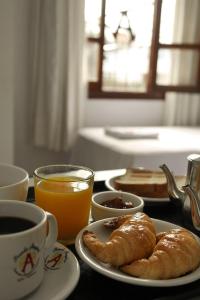 a table with a plate of pastries and a cup of coffee at PASEO GüEMES HOTEL in Salta