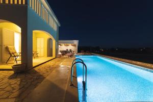 a swimming pool in front of a house at night at Villa Green Oasis in Lovreć
