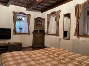a bedroom with a bed and a clock and windows at Ádi Vendégház - Bekecs in Bekecs