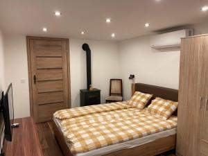 a bedroom with a bed with a checkered blanket at Ádi Vendégház - Bekecs in Bekecs +16 photos