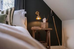 a table with a lamp on it next to a bed at Roost in Heyshott in Midhurst