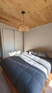 a large blue bed in a bedroom with a wooden ceiling at Aire in La Estancia