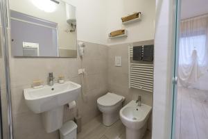 a bathroom with a sink and a toilet and a mirror at Casetta in Via Dini in Padova