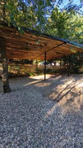 a wooden pavilion sitting under a tree in a park at Aire in La Estancia +2 photos