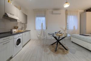a kitchen with a washing machine and a table at Casetta in Via Dini in Padova +11 photos