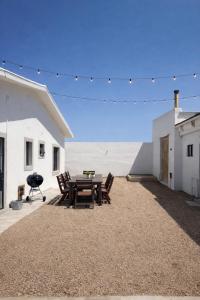 a patio with a table and chairs on a gravel yard at Huis Prins in Prince Albert