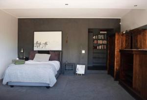 a bedroom with a bed and a book shelf at Noordhoek Wellness Pilates in Noordhoek