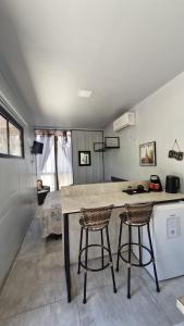 a kitchen with two bar stools and a counter at Pousada Encantos do Estaleiro in Balneário Camboriú