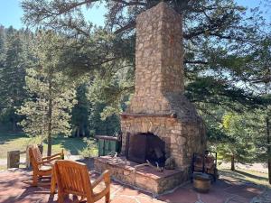 a stone fireplace sitting on a patio with two chairs at Skyline Ranch in High Rolls
