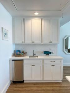 a kitchen with white cabinets and a sink at Blue Heron Hideaway in Rockport
