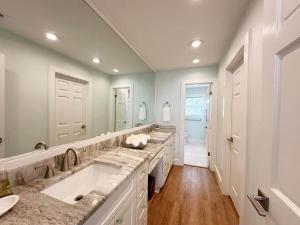 a bathroom with two sinks and a large mirror at Blue Heron Hideaway in Rockport