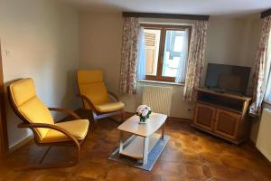 a living room with two chairs and a tv at Hôtel A la Vignette - COLMAR-NORD in Saint-Hippolyte +44 photos