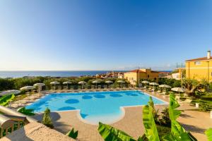 Blick auf einen Pool mit Sonnenschirmen und das Meer in der Unterkunft Hotel America in Marina di Camerota
