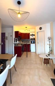 a living room with a table and a kitchen at Aéroport à pied, Escale 25 in Tillé