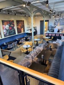 a restaurant with tables and chairs and a bar at Hotel Oostereiland in Hoorn