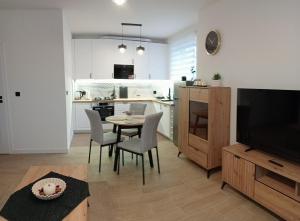 a kitchen and living room with a table and chairs at Apartament 42 in Sosnowiec