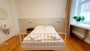 a white bed in a small room with a window at Zimmer im Erdgeschoss in Mannheim +4 photos