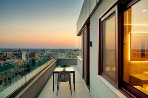 a balcony with a table and a view of a city at Zeus Thessaloniki Lazart in Thessaloniki