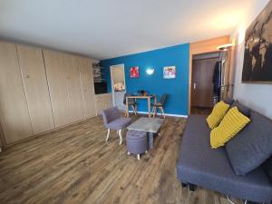 a living room with a couch and a table at Panorama 20, Grosses Studio, Nahe Ski-Pisten, Parkplatz in Leukerbad