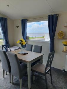 a dining room table and chairs with a view of the ocean at Jasper Lodge in Morecambe