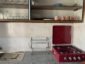 a kitchen with a red stove and a shelf at Kisumu gateway 2br in Kisumu +43 photos
