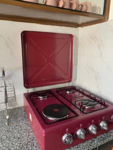 a red stove top oven sitting on a counter at Kisumu gateway 2br in Kisumu