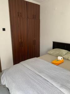 a bedroom with a bed with a wooden cabinet at Kisumu gateway 2br in Kisumu