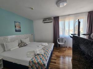 a bedroom with a bed and a desk and a window at Chance Sarafovo in Burgas