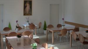 a room with tables and chairs and a painting on the wall at Haus St Vinzenz in Berlin