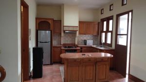 a large kitchen with wooden cabinets and a refrigerator at Happy Place Antipolo in Antipolo +2 photos