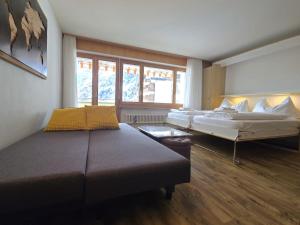 a bedroom with two beds and a large window at Panorama 20, Grosses Studio, Nahe Ski-Pisten, Parkplatz in Leukerbad
