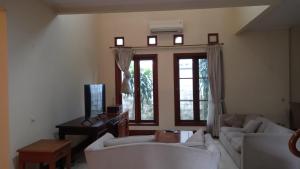 a living room with two white couches and a television at Happy Place Antipolo in Antipolo