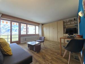 a living room with a couch and a table and a desk at Panorama 20, Grosses Studio, Nahe Ski-Pisten, Parkplatz in Leukerbad