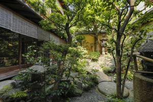 a garden with rocks and trees in front of a building at Ryokan Sanga in Kyoto
