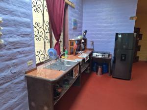 a kitchen with a sink and a refrigerator at Casa Solomaco in Vilcabamba