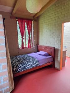 a small bed in a room with a window at Casa Solomaco in Vilcabamba