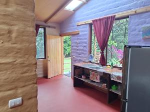 a kitchen with a refrigerator and a window at Casa Solomaco in Vilcabamba