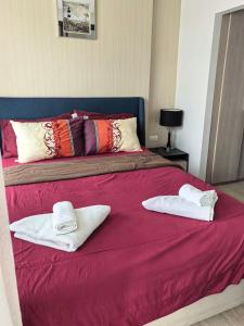 a bed with two towels on top of it at Centrio phuket 07 in Ban Rangeng