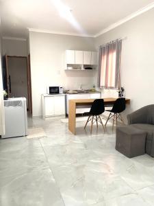a kitchen and living room with a table and chairs at Studio Aconchegante e Moderno in Castanhal