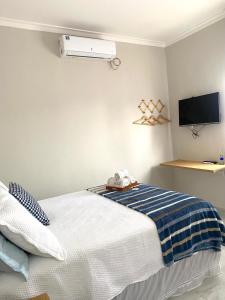 a bedroom with a bed and a air conditioner on the wall at Studio Aconchegante e Moderno in Castanhal +4 photos