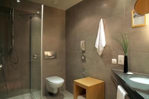 a bathroom with a shower and a toilet and a sink at Zeus Thessaloniki Lazart in Thessaloniki +59 photos
