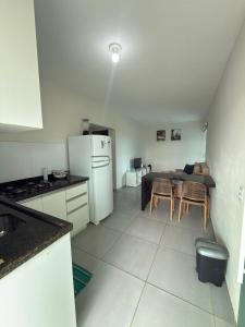 a kitchen with a refrigerator and a table with chairs at Maragogi Peroba Ville Residence in Maragogi +3 photos