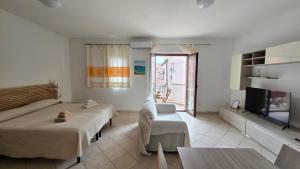 a living room with two beds and a tv at Monolocale in centro con parcheggio privato! in Palau