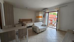 a living room with a table and a chair at Monolocale in centro con parcheggio privato! in Palau +11 photos